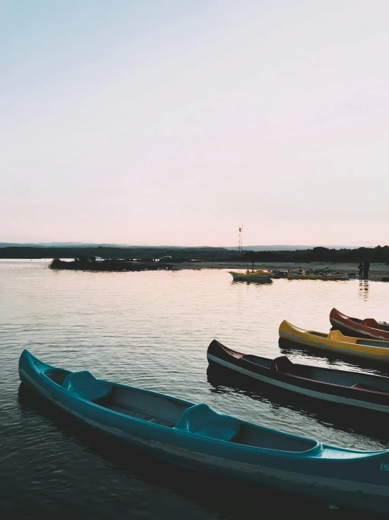 a group of canoes sitting on top of a body of water, happening, in the evening, on the coast, trending on vsco, mediterranean fisher village