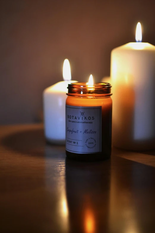 a couple of candles sitting on top of a table, product image, citrinitas, jar on a shelf, softly lit