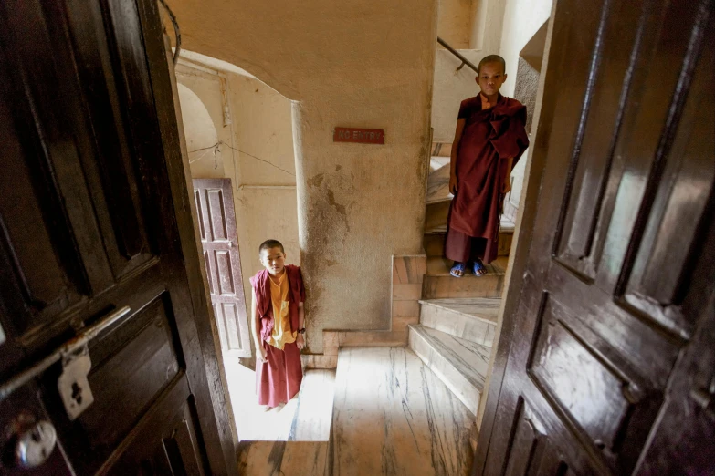 a couple of people that are standing in a doorway, inspired by Steve McCurry, unsplash, buddhist monk meditating, hogwarts stairwell, myanmar, 2 5 6 x 2 5 6 pixels