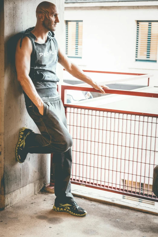 a man leaning against a wall next to a window, happening, wearing fitness gear, wearing a camisole and boots, in gunmetal grey, trending on imagestation