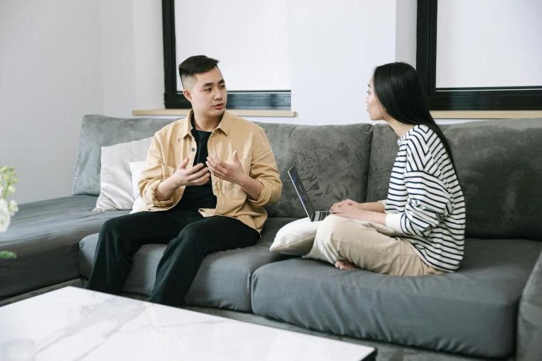 a man and a woman sitting on a couch, pexels, ross tran and bayard wu, talking, grey, helpful
