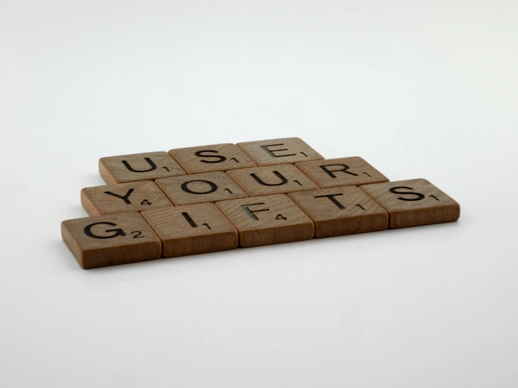 three pieces of wooden type blocks spelling use your gifts