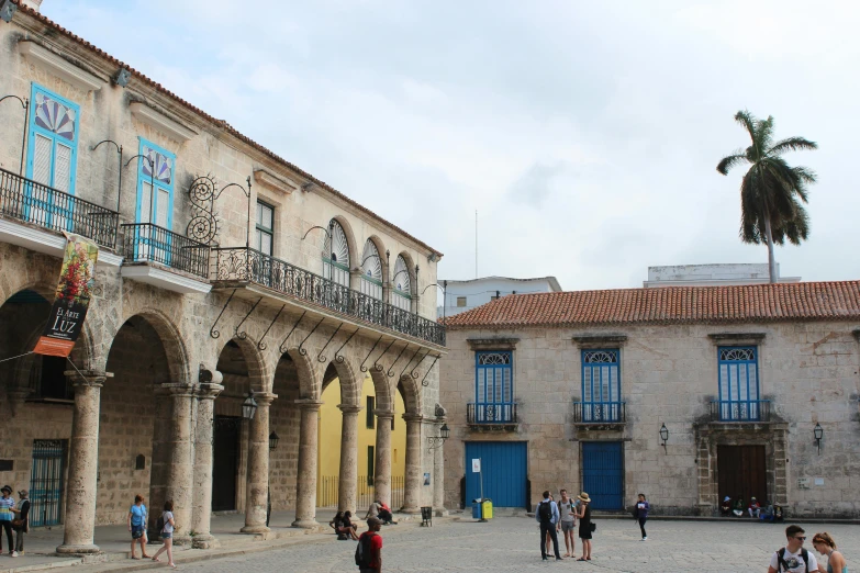 a group of people walking on a walkway outside of a large building