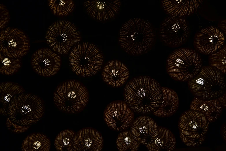 a bunch of balls of yarn sitting on top of a table, a digital rendering, inspired by Ross Bleckner, conceptual art, glowing spores flying, black and gold colors, microscopic view, bottom - view