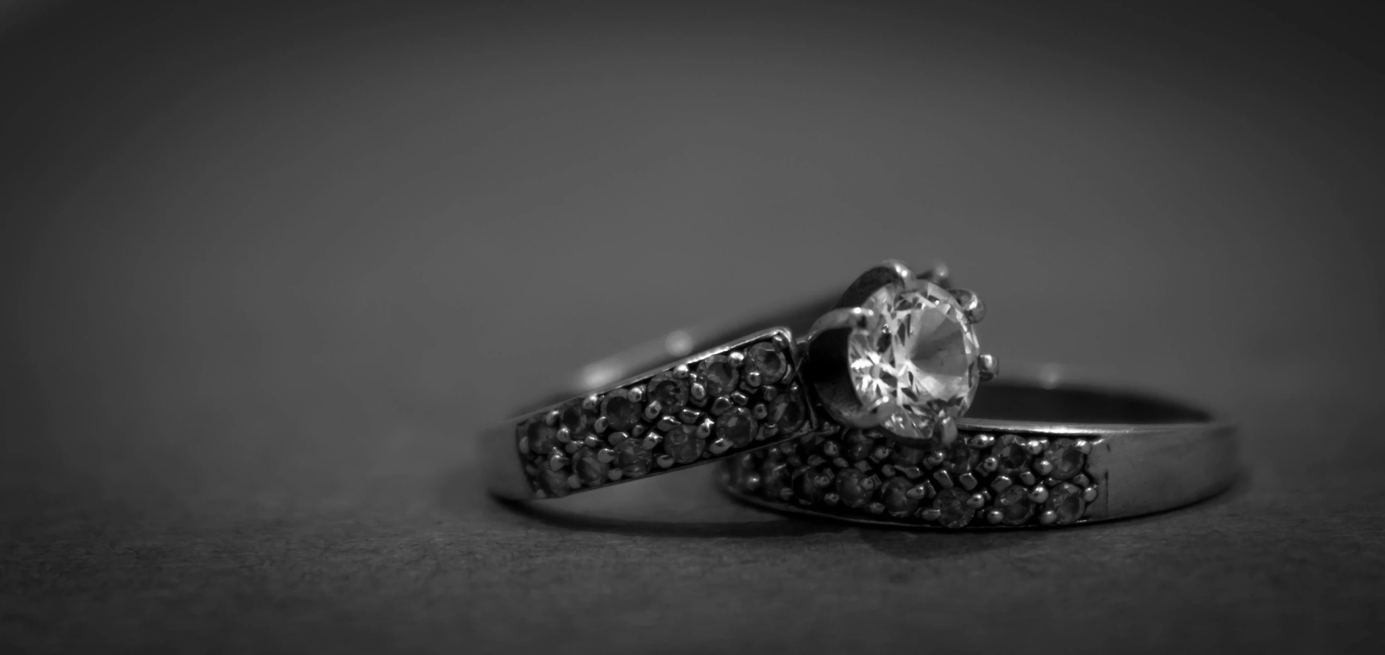 a couple of wedding rings sitting on top of a table, a black and white photo, by Mathias Kollros, pixabay, renaissance, crystal encrusted, hook as ring, listing image, black magic crystal ring