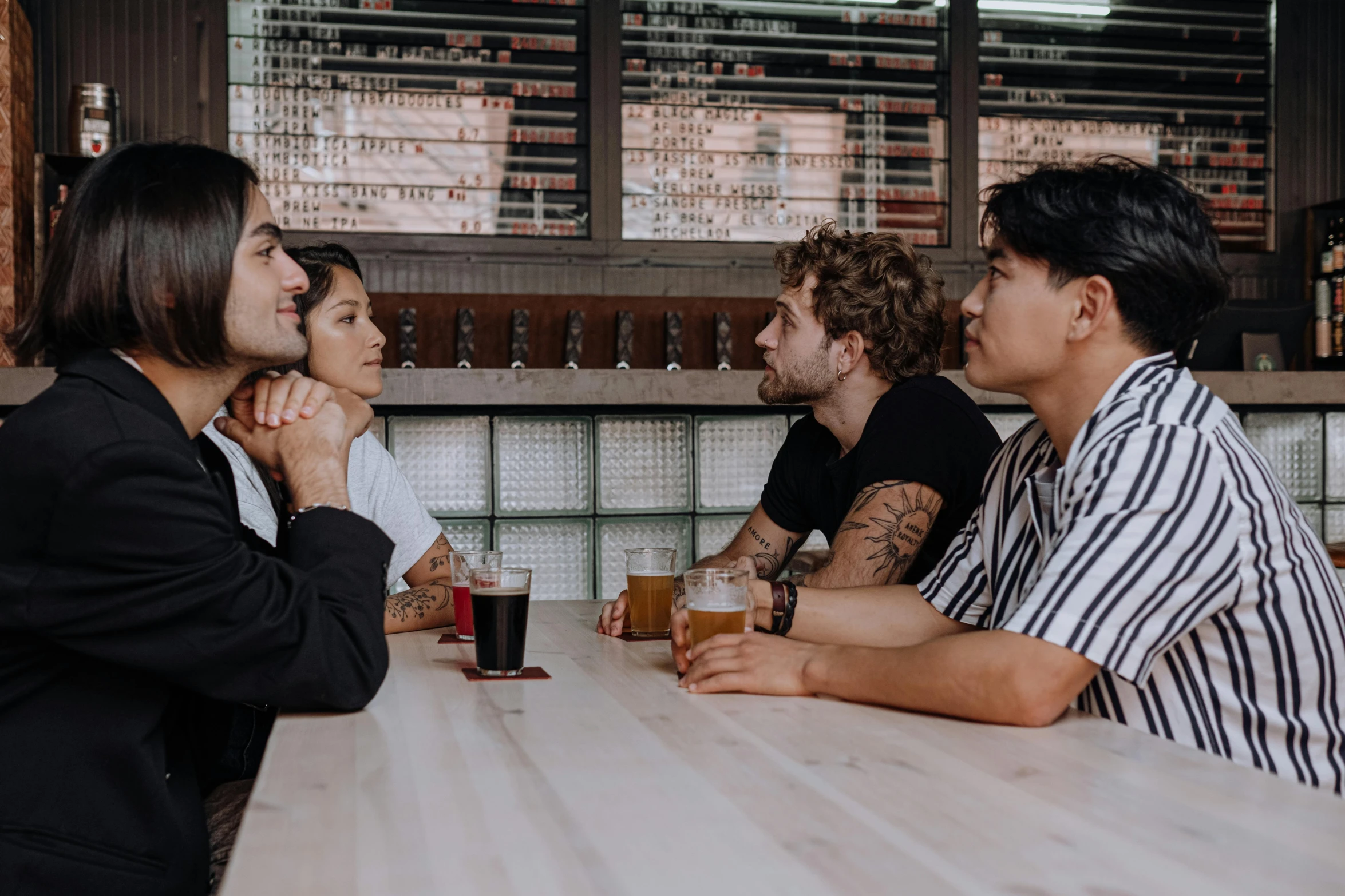 a group of people sitting around a wooden table, by Carey Morris, pexels contest winner, looking at each other mindlessly, aussie baristas, beer, lgbtq