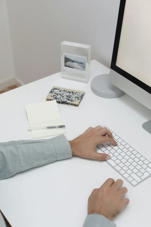 a man sitting at a desk using a computer, a computer rendering, by Carey Morris, trending on unsplash, white sleeves, ignant, pearlescent white, keyboard