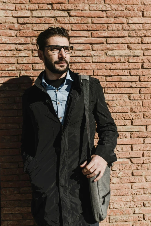 a man in a long vest posing for the camera