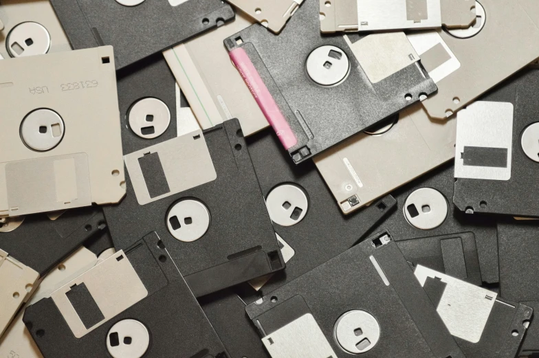 a pile of floppy disks sitting on top of a table, unsplash, computer art, vhs artefacts, 1990's, ignant, demolition