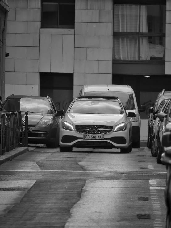 a black and white photo of cars parked in a parking lot, a black and white photo, by Daniel Gelon, pexels contest winner, les automatistes, mercedez benz, overcast!!! cinematic focus, in an alley, annoyed