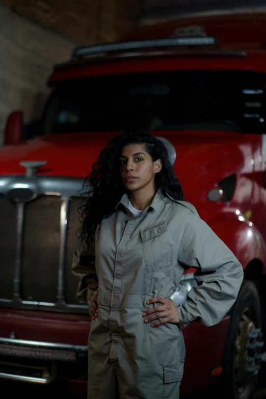 a woman standing by a red truck in the dark