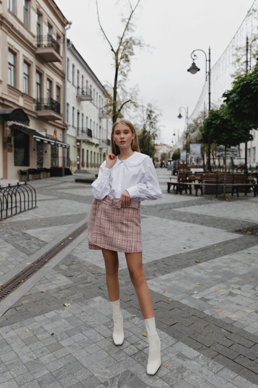 a woman standing in the middle of a street, by Emma Andijewska, trending on unsplash, renaissance, detailed plaid miniskirt, white and light-pink outfit, 😭 🤮 💕 🎀, neo kyiv