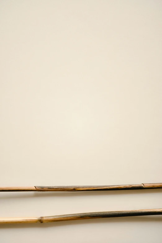 two wooden stick are sitting on a white surface