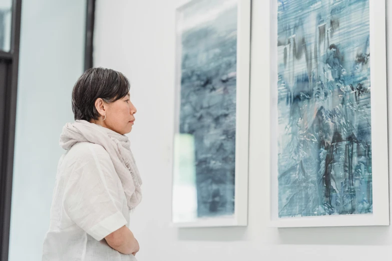 a woman looking at paintings on a wall, a photorealistic painting, inspired by Wang Shishen, unsplash, yoji shinkawa : : portrait, profile image, etsuko miura, scenery