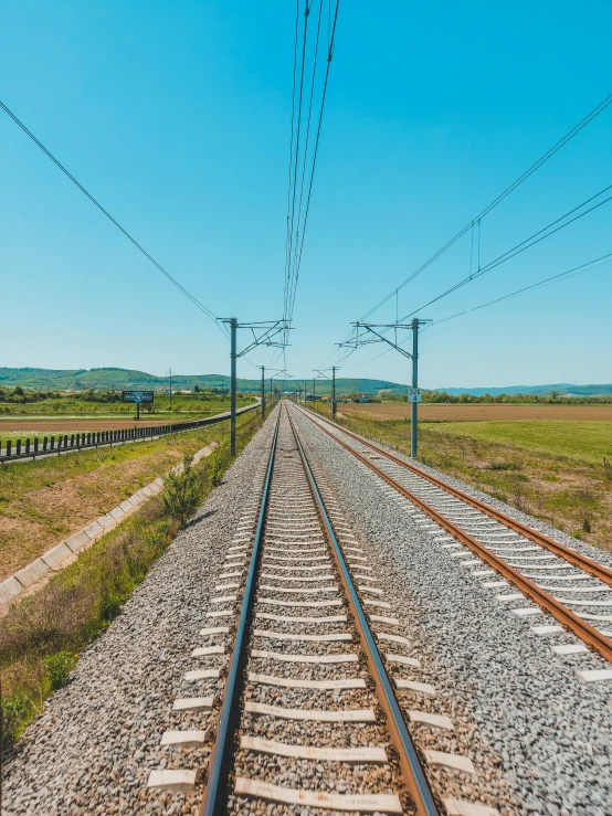 an empty train track in the middle of nowhere, pexels contest winner, hyperrealistic symmetrical 8k, overhead wires, 🚿🗝📝