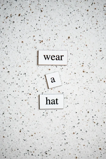 a couple of pieces of paper that say wear a hat, by Nina Hamnett, unsplash, visual art, concrete poetry, academic clothing, smallest waistline, ta ha