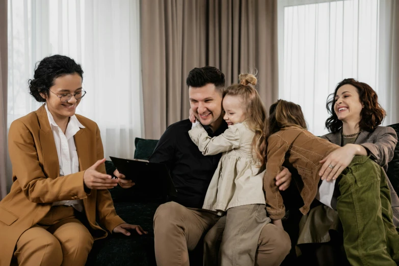 a group of people sitting on top of a couch, with a kid, profile image, professional image, trending photo