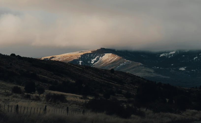 a distant view of the mountain range covered in white and brown light