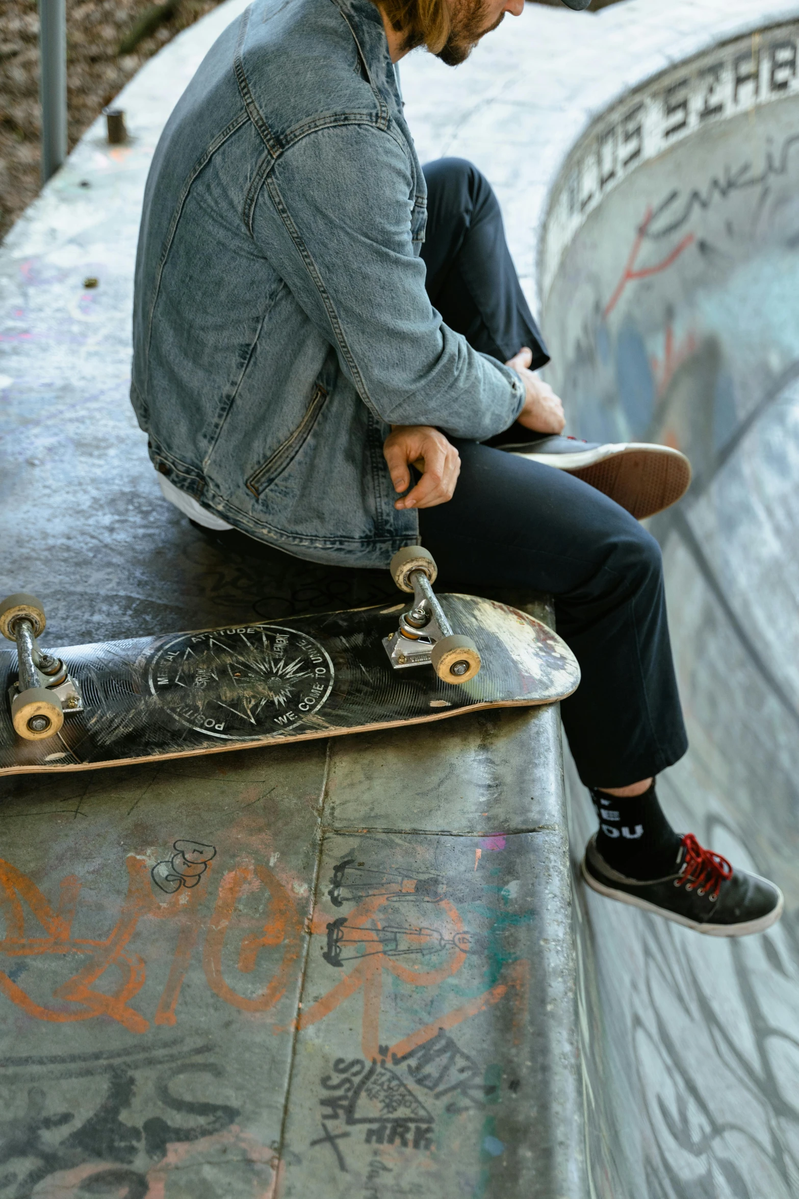 a man riding a skateboard up the side of a ramp, trending on pexels, graffiti, sitting with wrists together, textured, studs, hipster dad