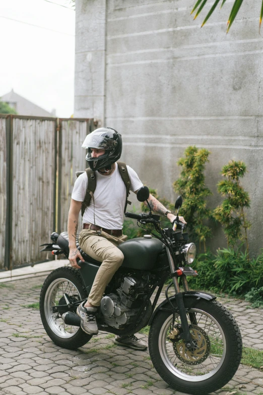 a man riding on the back of a motorcycle, inspired by Alex Petruk APe, unsplash, wearing cargo pants, bali, halfbody headshot, at home