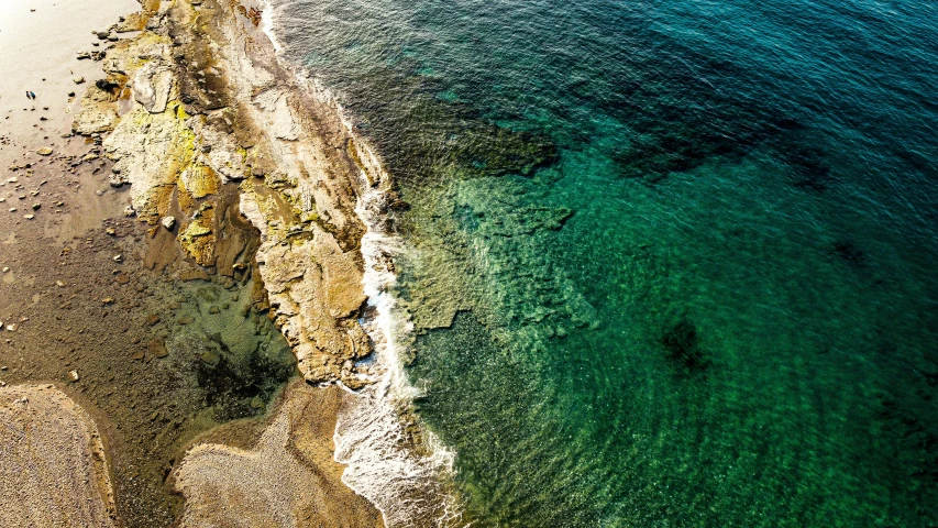 a large body of water next to a cliff, by Giuseppe Avanzi, pexels, top - down photograph, sea - green and white clothes, rhode island, details and vivid colors