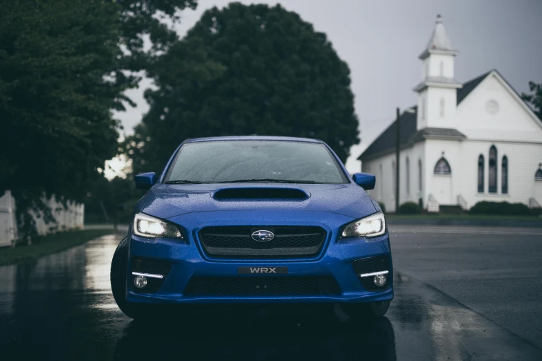 the front of a blue subarunt on the street