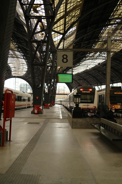 a train station with two trains parked next to each other, inspired by Eva Gonzalès, madrid, 8k!!, spacious, hannover