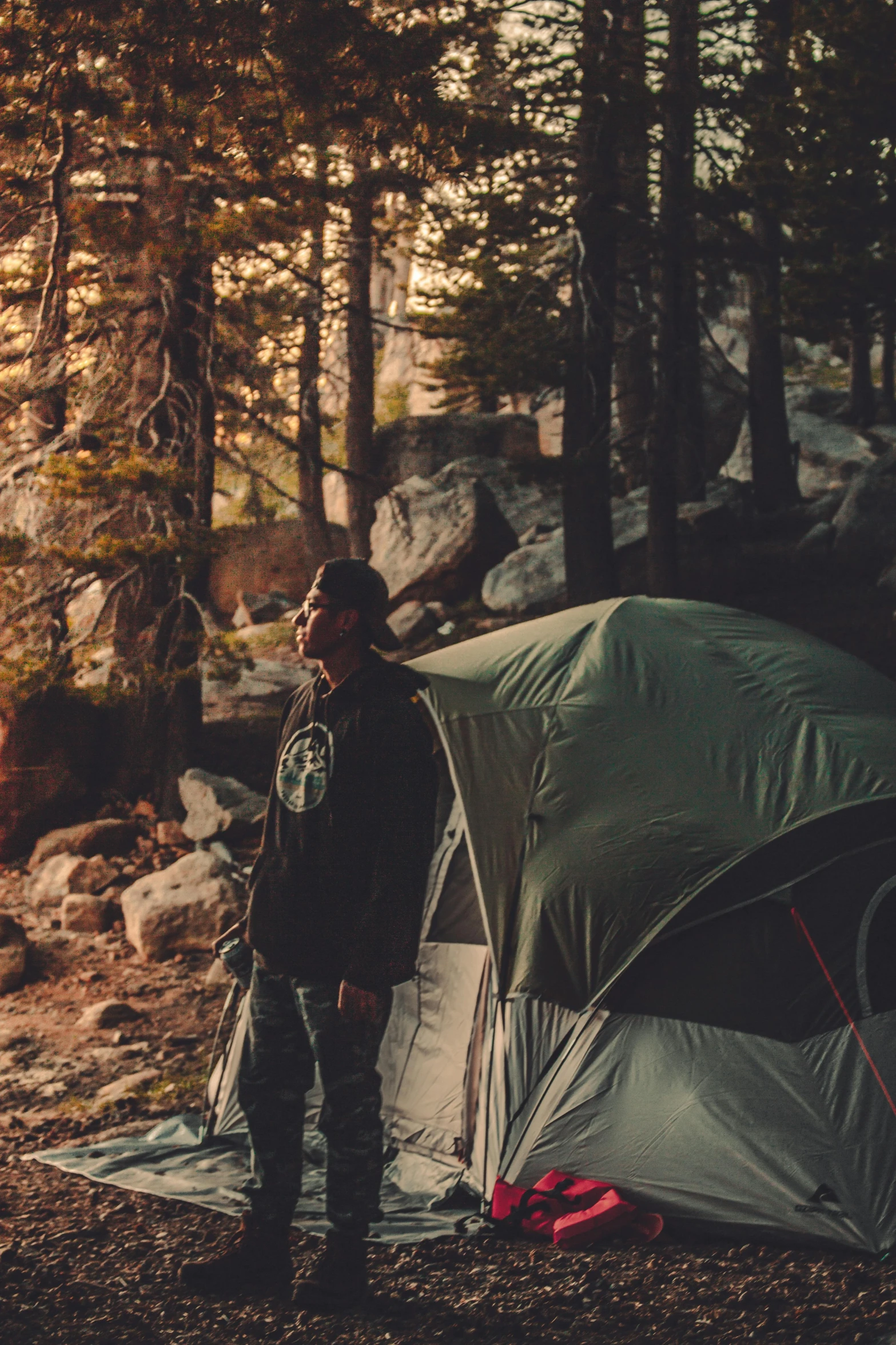 a man standing next to a tent in the woods, by Niko Henrichon, trending on unsplash, renaissance, yosemite, instagram story, orelsan, high-quality photo