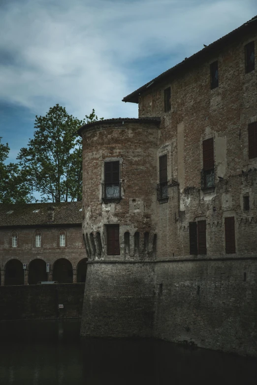 an old building is sitting by a small bridge