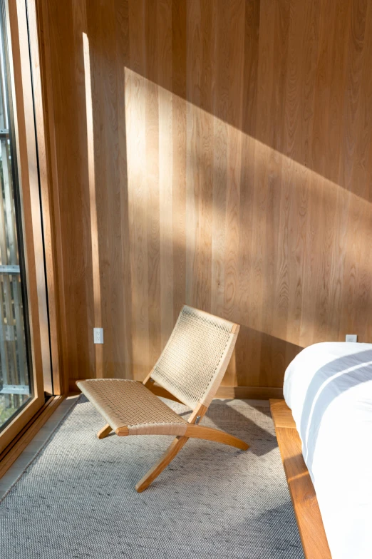 a wicker chair on the floor near a bed