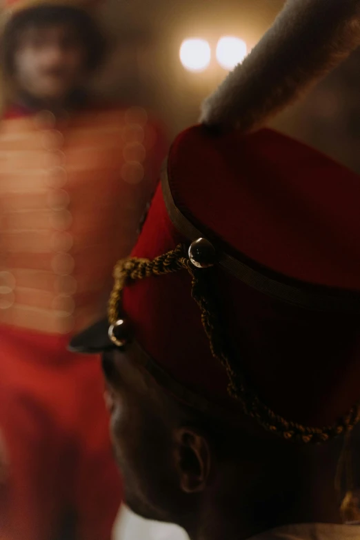 a black man in a hat looks at a mirror