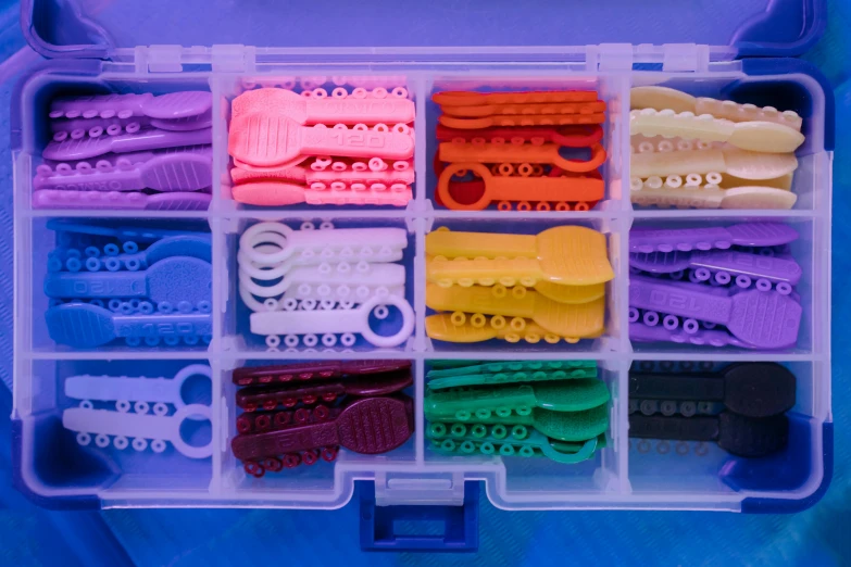 a plastic box filled with lots of different colored clips, inspired by Cerith Wyn Evans, modular constructivism, underwater soft colours, educational display case, colourful close up shot, pixel sorted