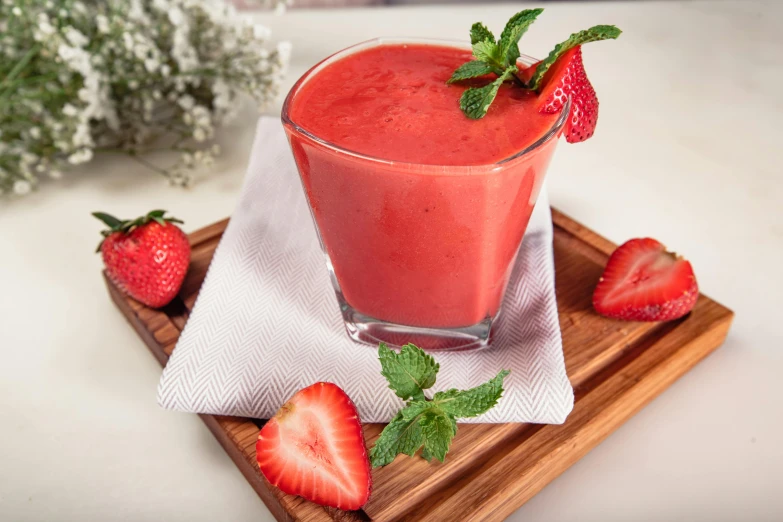 a glass filled with fruit sitting on top of a wooden tray, strawberry, detailed product image, coral red, milkshake