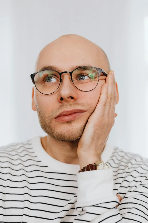 a bald man wearing glasses and a striped shirt, trending on pexels, antipodeans, attractive androgynous humanoid, contemplating, dasha taran, male with halo