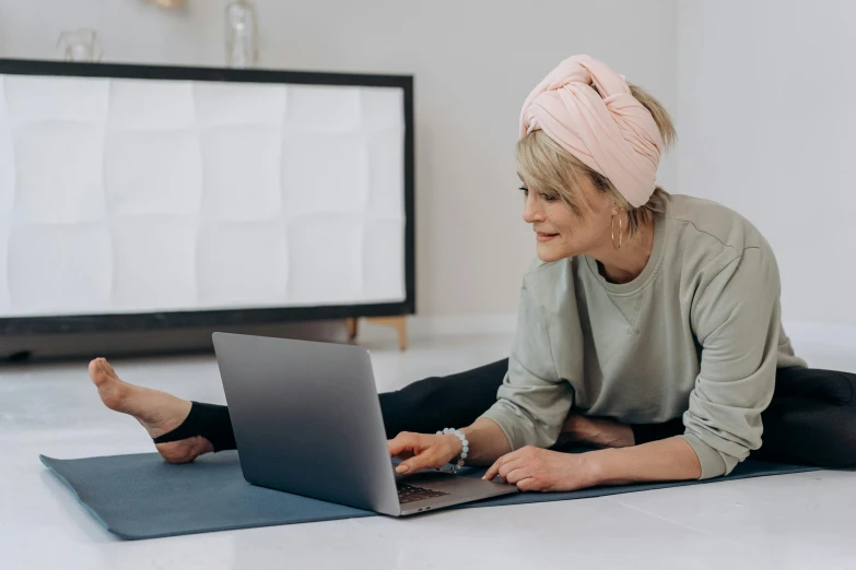 a woman laying on the floor using a laptop, trending on pexels, wearing a headband, older woman, link from zelda using computer, avatar image