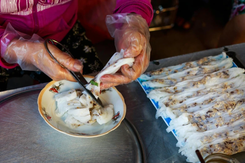 a close up of a plate of food on a table, fishing village, holding a squid, plastic wrap, phong shaded