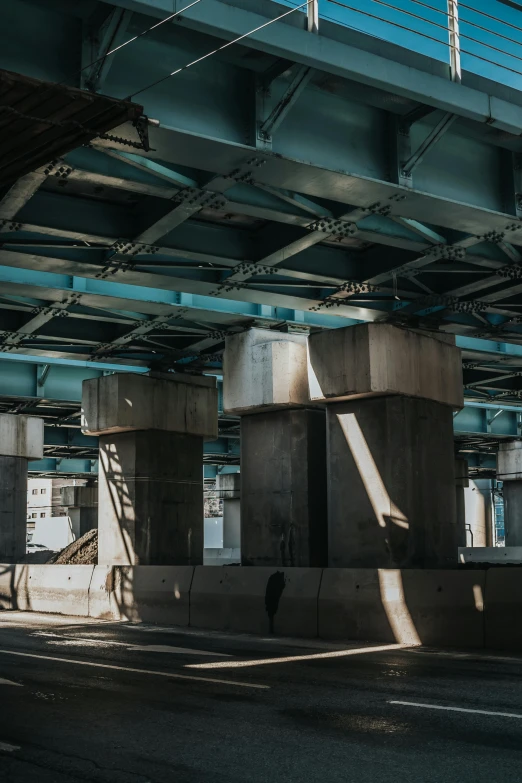 a person riding a motorcycle under a bridge, inspired by Elsa Bleda, unsplash contest winner, brutalism, conveyor belts, teal aesthetic, afternoon sunlight, multiple levels