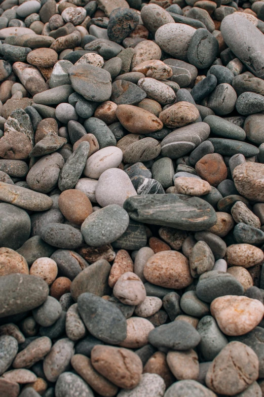 a pile of rocks sitting on top of a beach, smooth rounded shapes, zoomed out to show entire image, unsplash 4k, 1 6 x 1 6