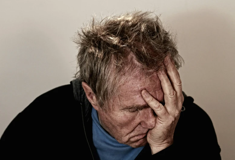 a man sitting at a table with his head in his hands, pexels, grumpy [ old ], a photo of a disheveled man, profile image, people crying
