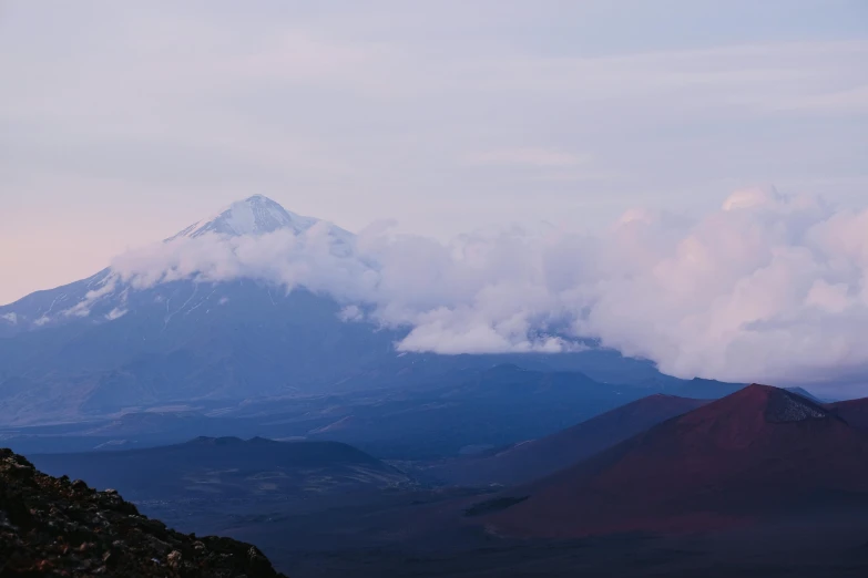 clouds hang over the top of mountain tops