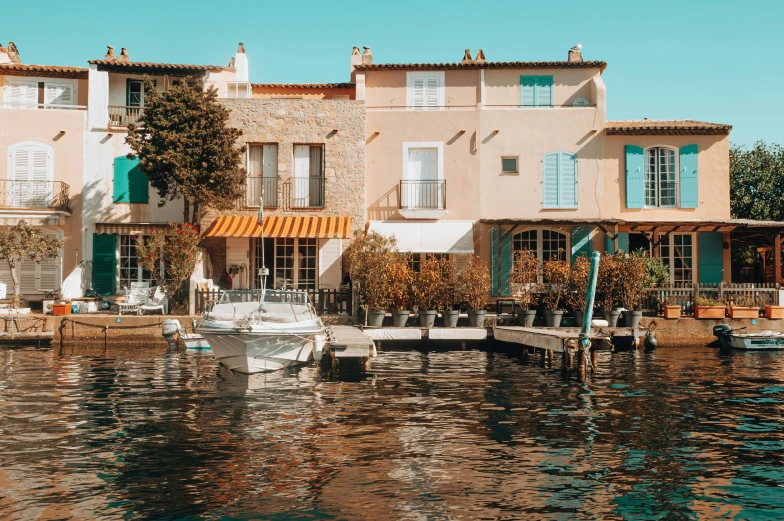 boats parked outside a group of houses next to the ocean