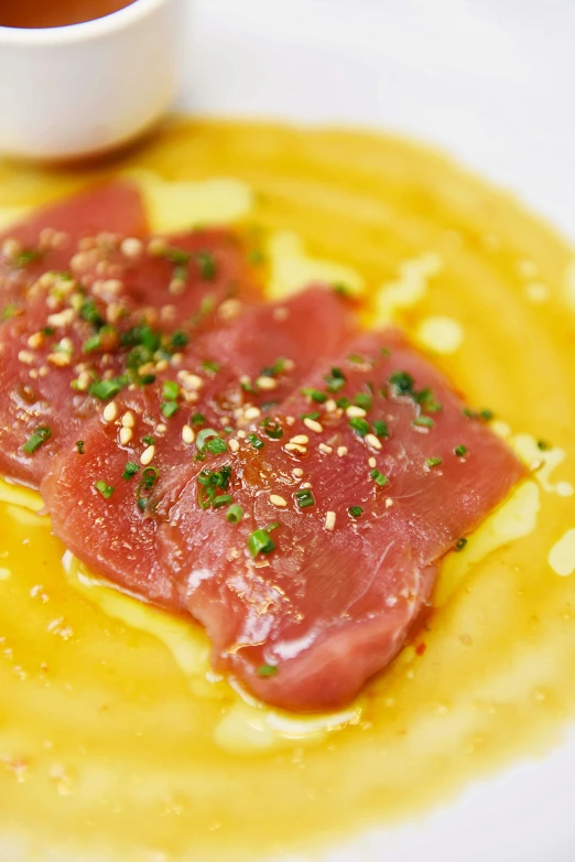 fish sitting on a white plate with sauce and garnish