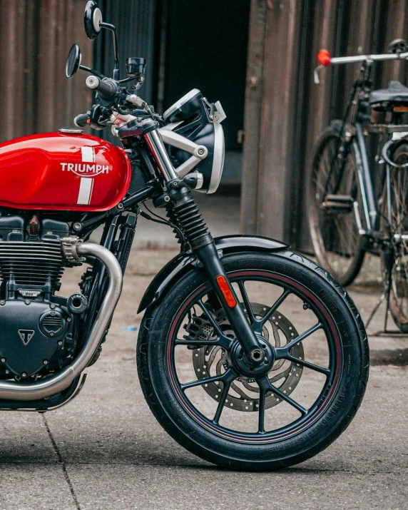 a red motorcycle parked in front of a building, triumph, detailed product image, detail shot, deus ex machina