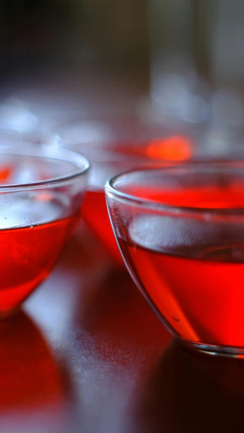 two bowls of red liquid sitting on a table, by Adam Chmielowski, pexels, ap photo, schnapps, bubbly, minn