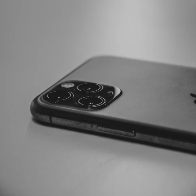 an iphone sitting on top of a table, a black and white photo, black plastic, close-up product photo, photographic print, low angle photo