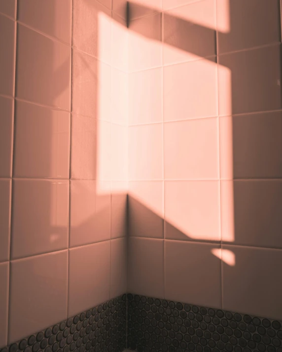 a bathroom that has white tile walls with a light coming through the window