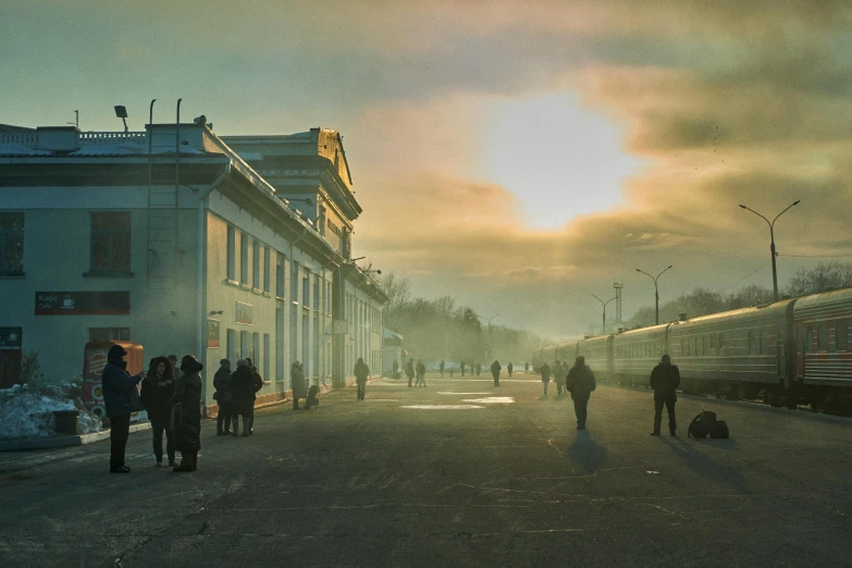 people walk down a street while the sun sets