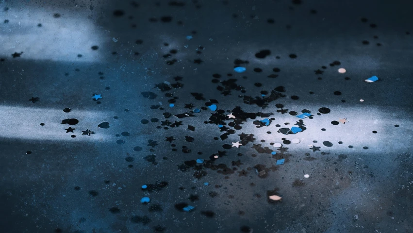 a close up of a black and blue object, a microscopic photo, inspired by Filip Hodas, trending on polycount, space art, rain falling, wet asphalt, stars reflecting on the water, blurred space