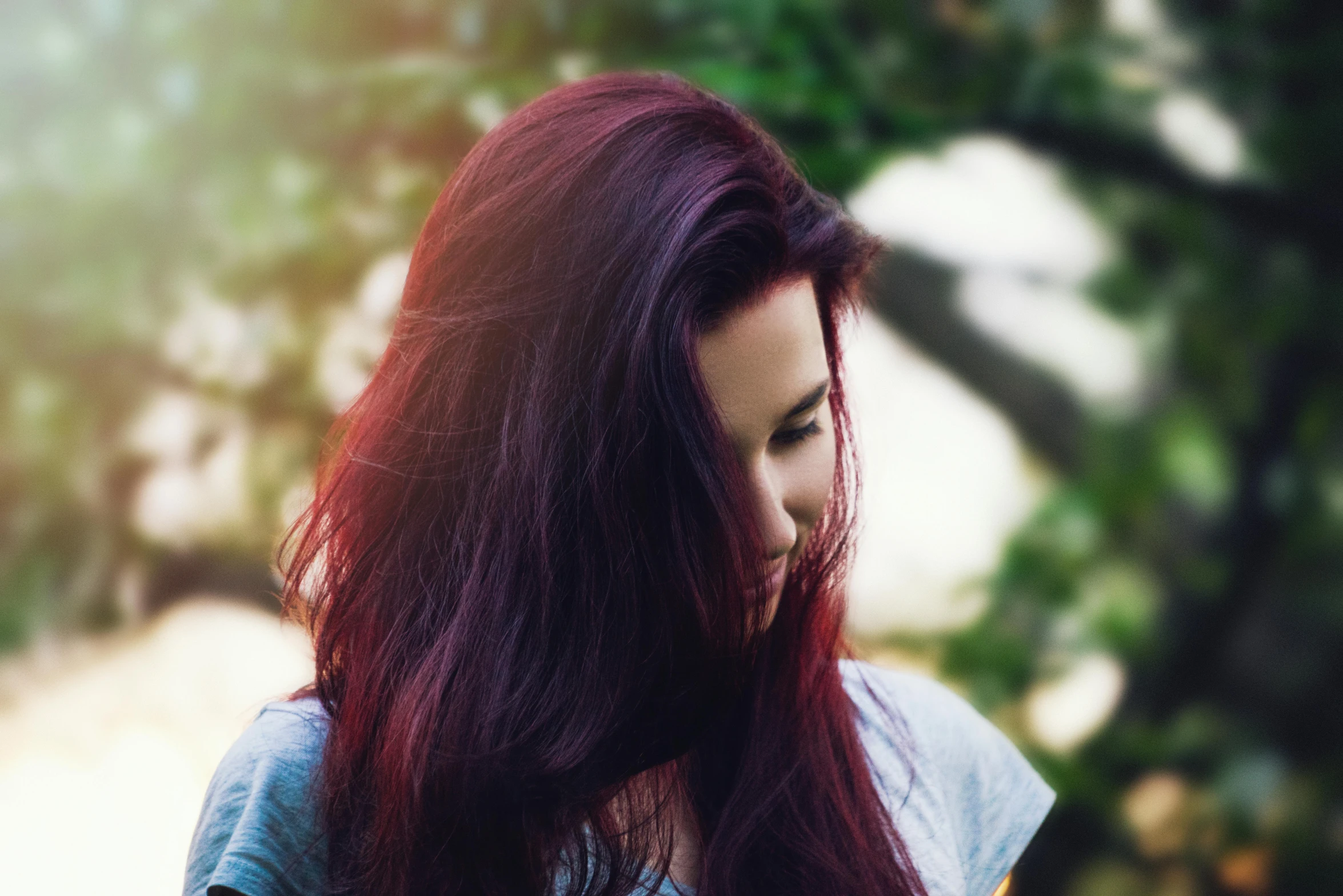 a woman looking down at her cell phone, inspired by Elsa Bleda, pexels contest winner, renaissance, deep purple hair, glowing crimson head, overexposed sunlight, second colours - purple