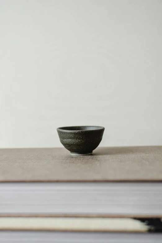 a black bowl sitting on top of a book